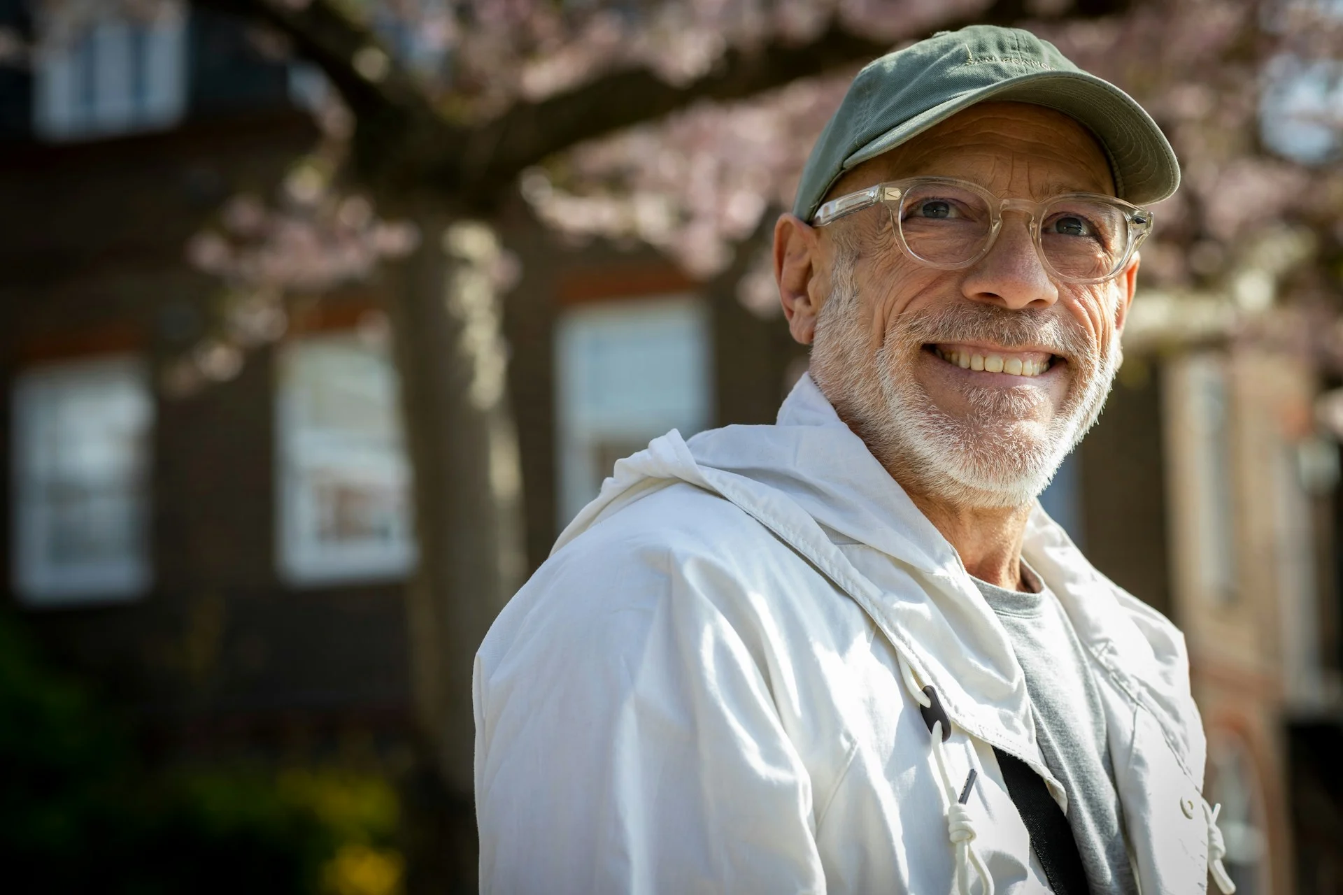 Smiling man in a cap and glasses outdoors