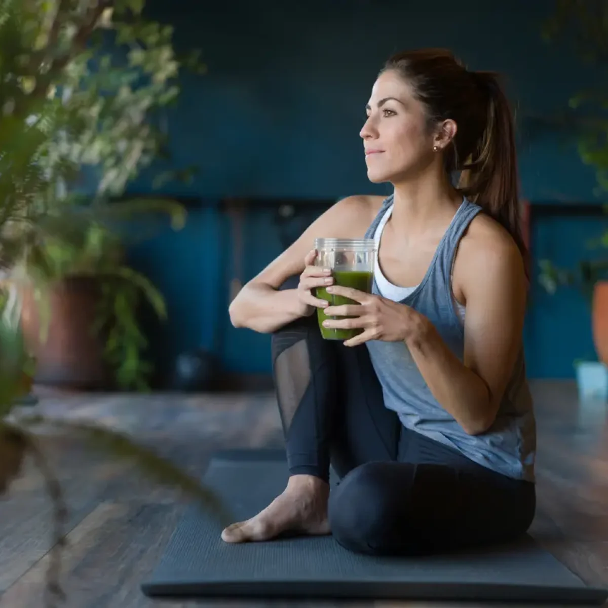 Fit woman drinking a green detox smoothie at the gym Portrait of a fit Latin American woman drinking a green detox smoothie at the gym - healthy lifestyle concepts