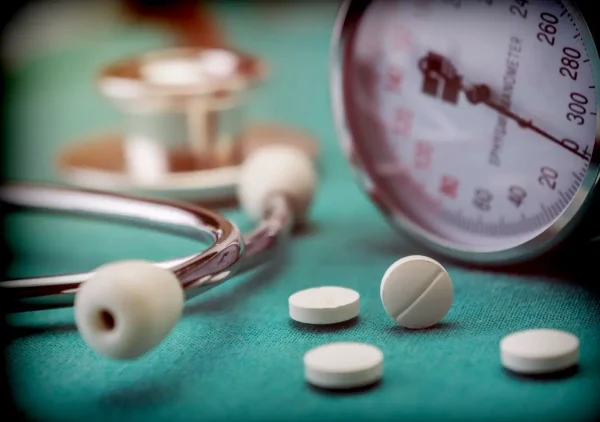 White pad next to a manometer to measure blood pressure and a stethoscope in a hospital, conceptual image